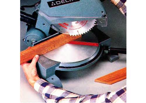 Use a clamp to hold the trim tight against the miter saw fence, lower the blade gradually, and keep your hands far away from the blade