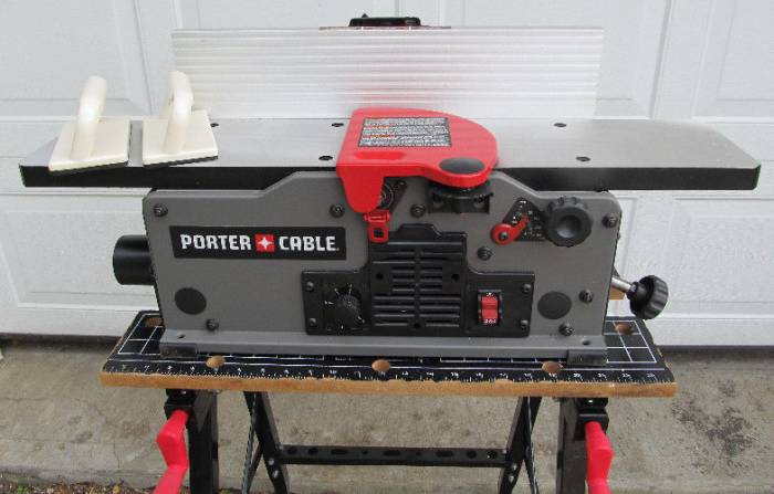 Porter-Cable PC160JT benchtop jointer placed over a Black & Decker Workmate in front of a white garage door