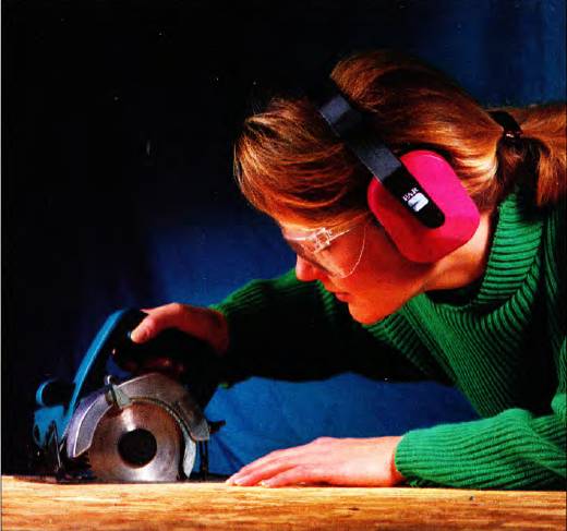 woman wearing hearing protection while using a circular saw