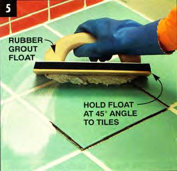 Use a rubber grout float and hold it at a 45-degree angle to the tiles