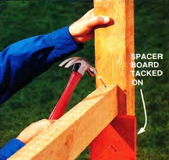 Tack on the 1x6 spacer board before toenailing the upper stringer to the post